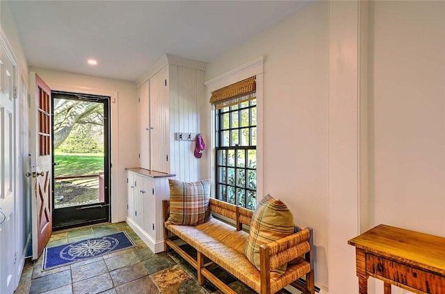 mudroom with a healthy amount of sunlight, stone finish floor, and recessed lighting