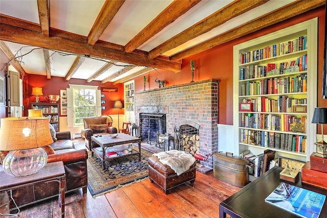 living room with wood-type flooring, a baseboard heating unit, a fireplace, and beamed ceiling