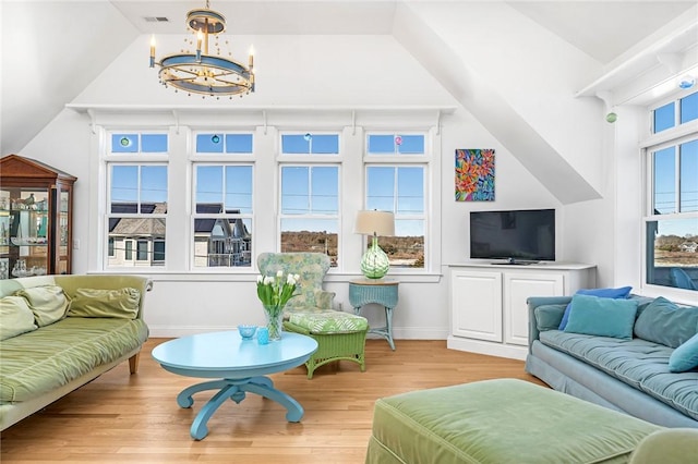 interior space featuring wood finished floors, baseboards, visible vents, a notable chandelier, and lofted ceiling