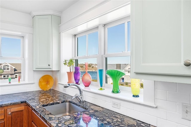 7 Clarkes Village Rd, Jamestown, RI 02835 - room details featuring a sink, decorative backsplash, dark stone countertops, and brown cabinets