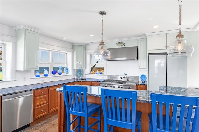 kitchen with stove, dark stone countertops, stainless steel dishwasher, extractor fan, and a sink