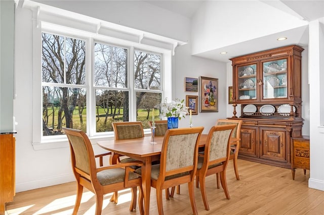 dining room featuring light wood finished floors, recessed lighting, baseboards, and plenty of natural light