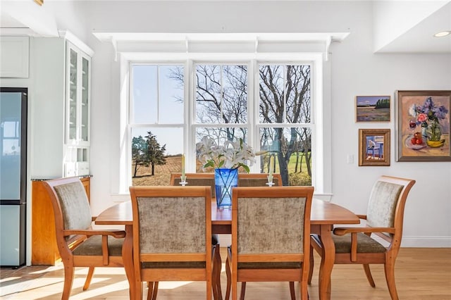 dining area featuring baseboards and light wood finished floors
