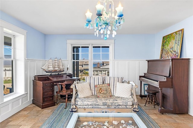 sitting room with stone tile flooring, a decorative wall, and plenty of natural light