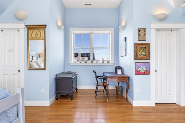 office area with visible vents, light wood-style flooring, and baseboards