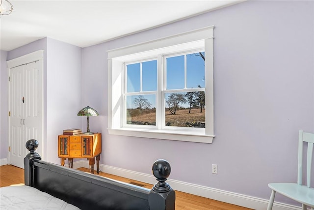 bedroom featuring a closet, baseboards, and light wood-type flooring