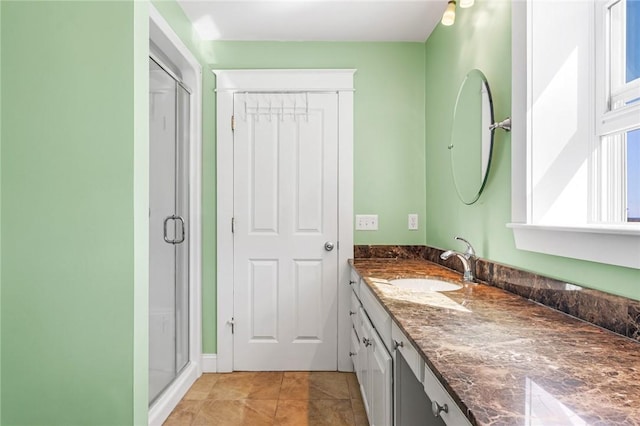 bathroom with tile patterned flooring, a shower stall, and vanity