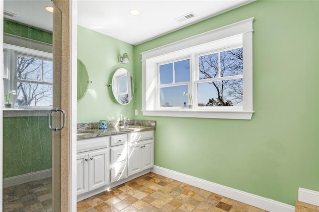 bathroom featuring a shower stall, vanity, visible vents, stone finish floor, and baseboards