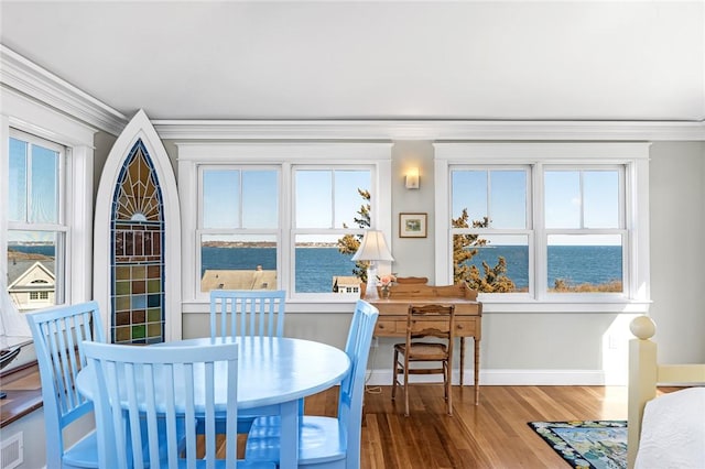 sunroom / solarium with visible vents and a water view
