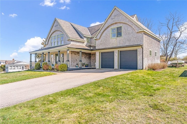 view of front of home featuring a porch, a front lawn, a garage, and aphalt driveway