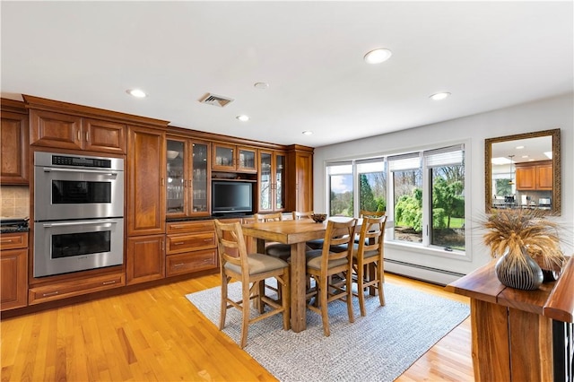 dining room featuring a baseboard heating unit, light wood finished floors, recessed lighting, and visible vents
