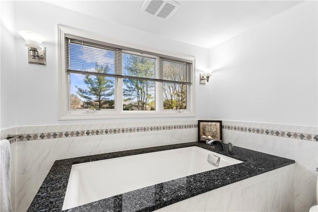 bathroom featuring a garden tub and visible vents