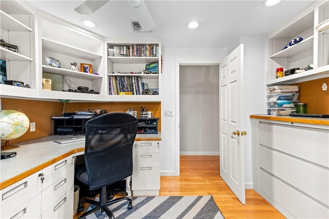 office space with built in desk, recessed lighting, visible vents, and light wood-type flooring
