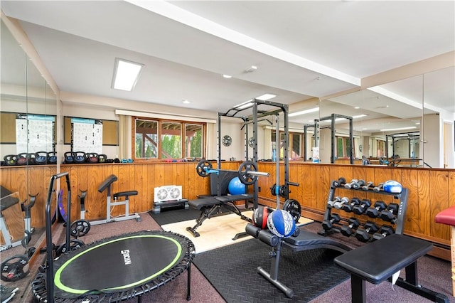 workout area featuring wood walls and carpet flooring
