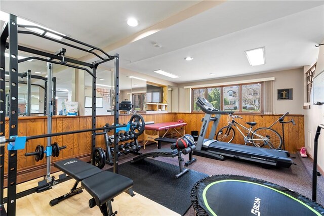 exercise room with wainscoting and wood walls