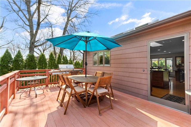 wooden deck with outdoor dining area and area for grilling