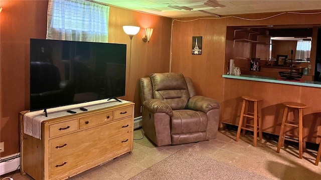 living area featuring a baseboard radiator and wooden walls