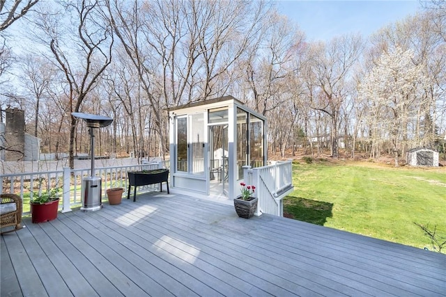 wooden deck with a yard and an outbuilding