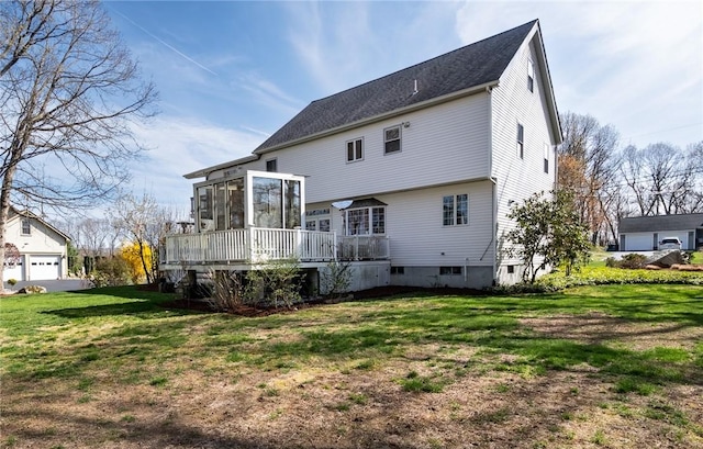 back of house featuring a sunroom, a deck, and a yard