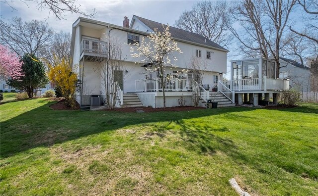 rear view of house with a sunroom, stairs, a chimney, and a balcony