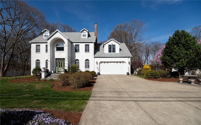 view of front of house with a front lawn, driveway, and a chimney