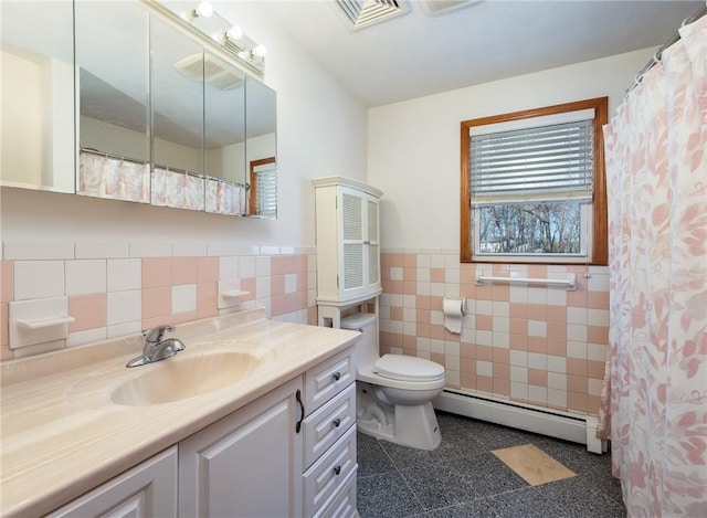 bathroom featuring wainscoting, tile walls, baseboard heating, toilet, and visible vents