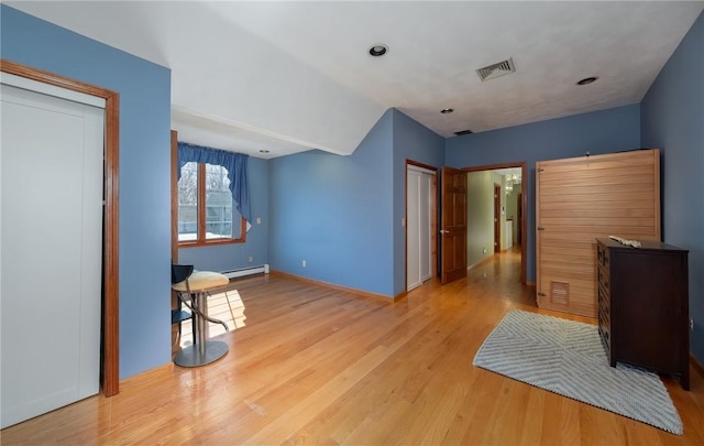 unfurnished bedroom with visible vents, baseboards, wood finished floors, and a baseboard radiator