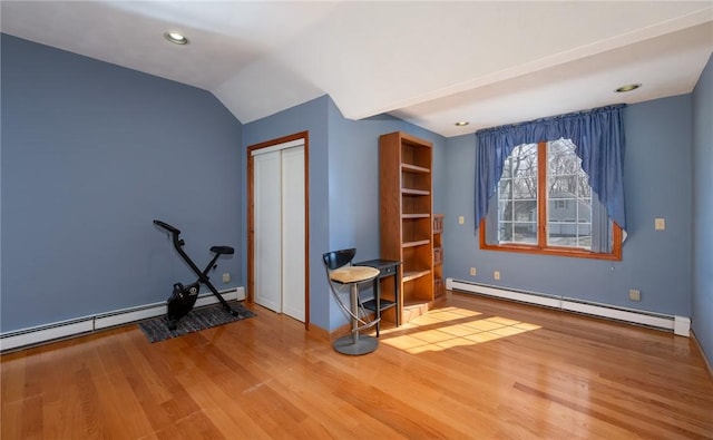 interior space featuring wood finished floors, baseboards, baseboard heating, and a closet