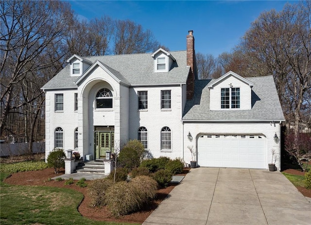 view of front of home with a shingled roof, driveway, a chimney, an attached garage, and french doors
