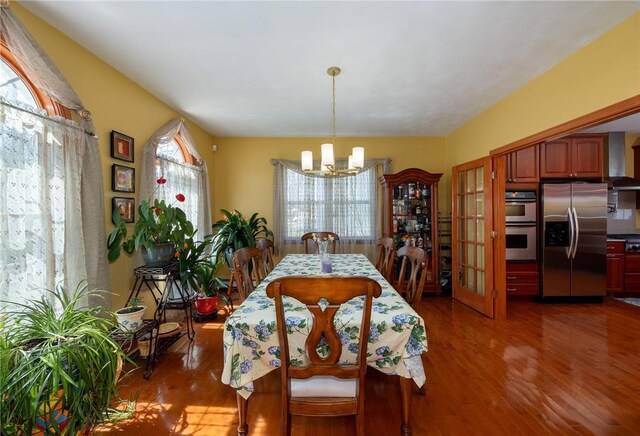 dining room featuring a notable chandelier and dark wood-type flooring
