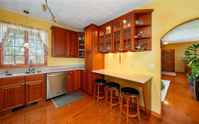 kitchen with visible vents, stainless steel dishwasher, light wood-style floors, and a sink
