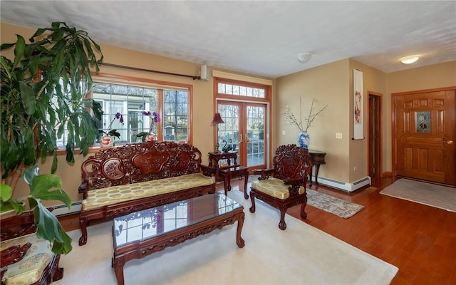 living room with a baseboard heating unit, french doors, wood finished floors, and baseboards