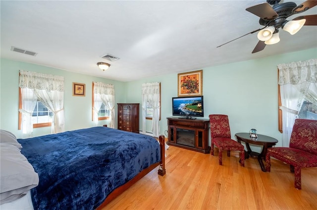 bedroom with visible vents, wood finished floors, and ceiling fan