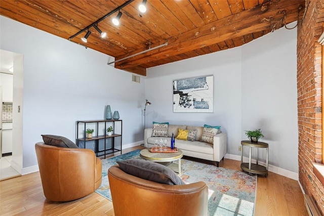 living area featuring track lighting, wooden ceiling, wood finished floors, and baseboards