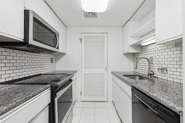 kitchen with tasteful backsplash, stainless steel appliances, open shelves, a sink, and light tile patterned flooring