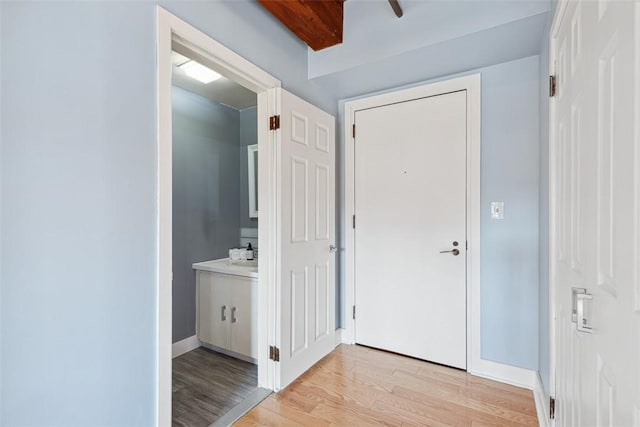 hallway featuring light wood-style flooring and baseboards