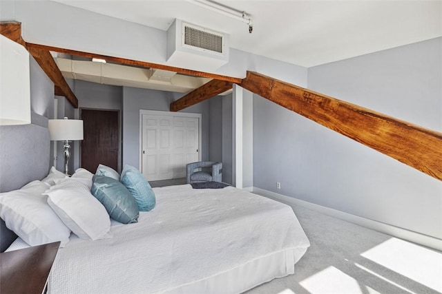 bedroom with visible vents, rail lighting, carpet floors, and baseboards