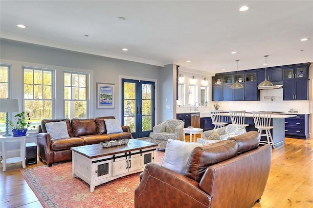 living area with ornamental molding, french doors, recessed lighting, and light wood-style flooring