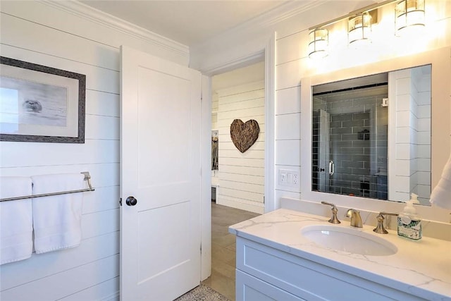 bathroom with vanity, ornamental molding, and wood walls