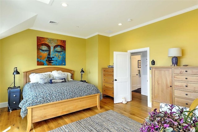 bedroom with baseboards, ornamental molding, light wood-type flooring, and visible vents