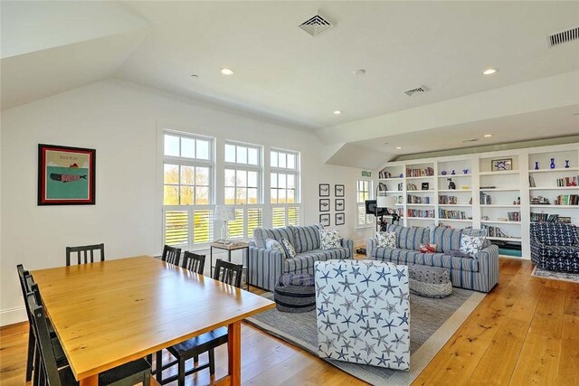 living room featuring visible vents, plenty of natural light, and lofted ceiling