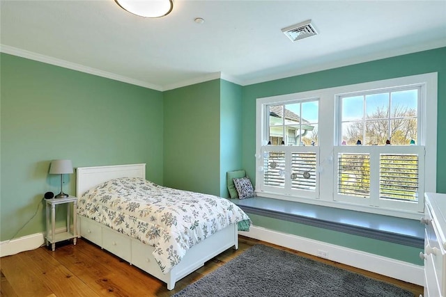 bedroom featuring baseboards, visible vents, ornamental molding, and dark wood-type flooring