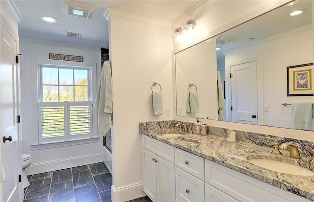 bathroom featuring a sink, baseboards, crown molding, and visible vents