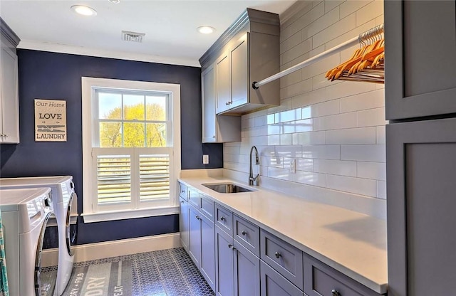 laundry area with visible vents, cabinet space, a sink, baseboards, and washer and dryer