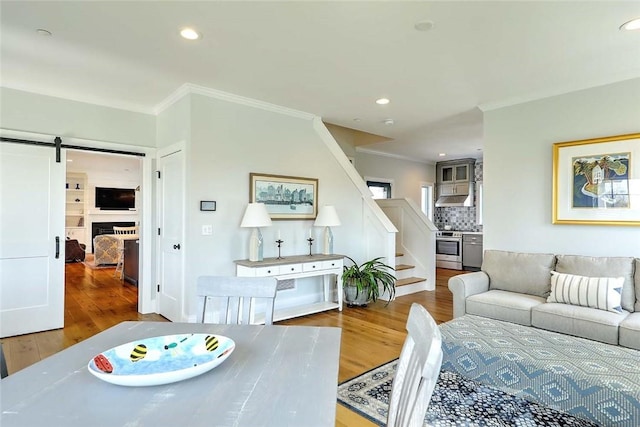 dining room with crown molding, recessed lighting, stairs, and wood finished floors