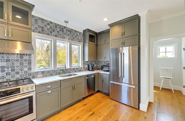 kitchen featuring gray cabinetry, plenty of natural light, stainless steel appliances, and under cabinet range hood