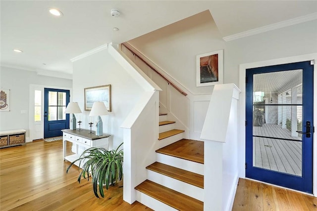 stairway with ornamental molding, recessed lighting, and wood finished floors