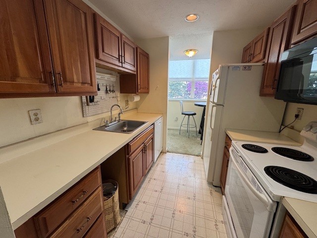 140 High St Unit 108, Westerly, RI 02891 - kitchen with light floors, light countertops, a sink, and white appliances