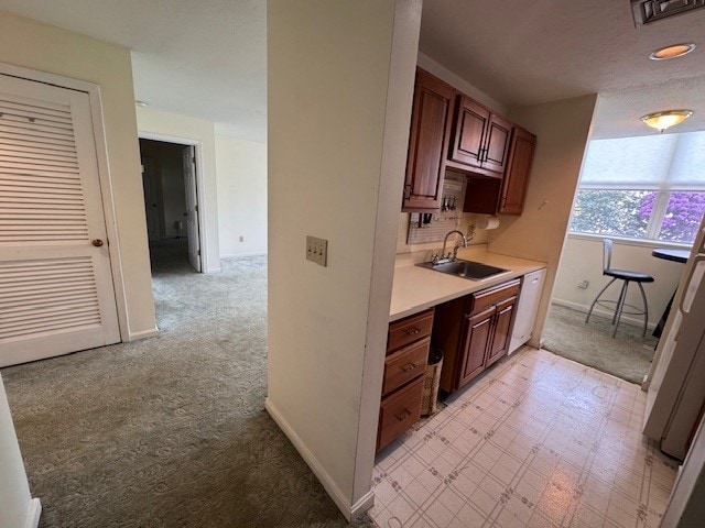 140 High St Unit 108, Westerly, RI 02891 - kitchen featuring a sink, visible vents, light countertops, baseboards, and dishwasher