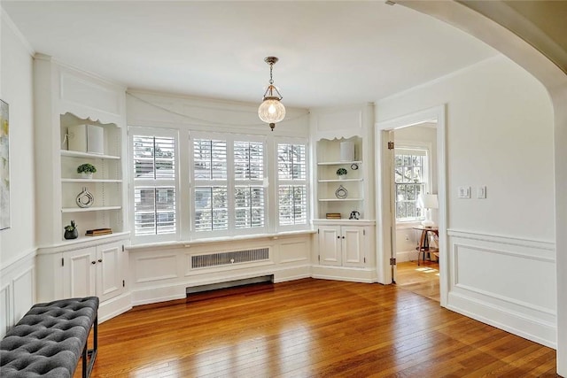 750 Elmgrove Ave, Providence, RI 02906 - dining room with built in features, wood-type flooring, a decorative wall, and arched walkways